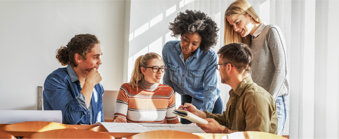 eine Gruppe junger Erwachsener sitzt in einem Seminarraum und redet miteinander
